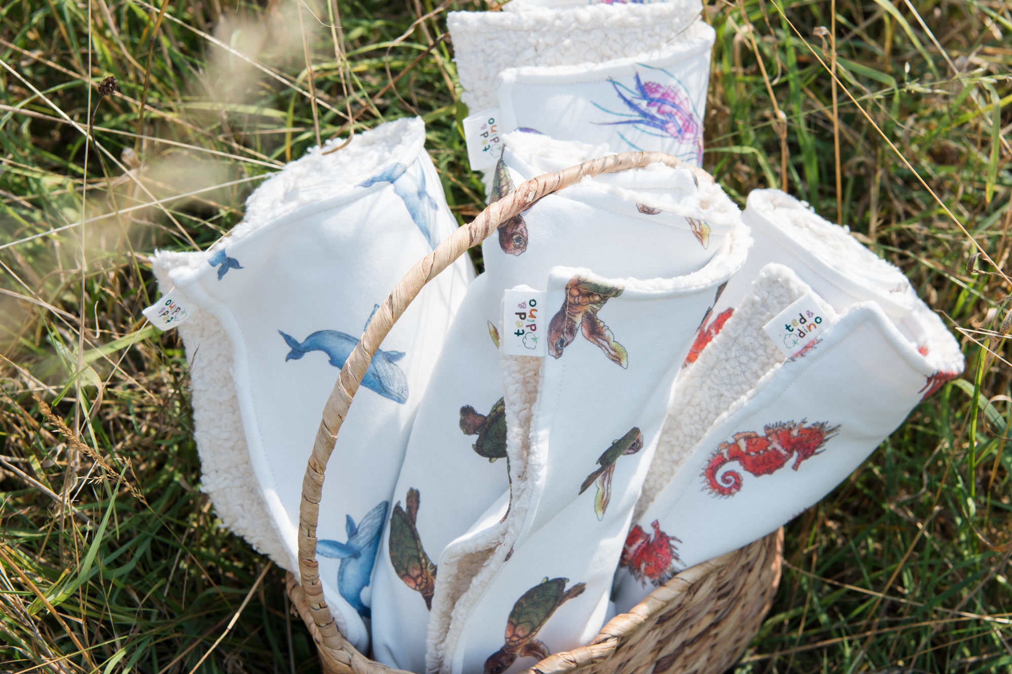 Organic white cotton blanket group shot in basket in grass field 3